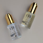 Two serums laying down. Hyaluronic Acid Serum and Bakuchiol Serum.